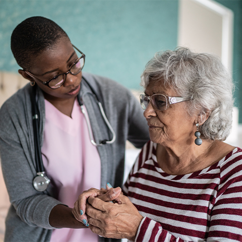 Female aide comforting senior woman who has dementia