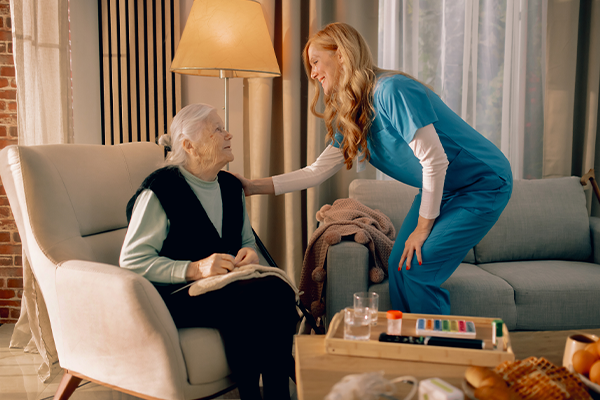 A compassionate female caregiver providing service to senior woman client in her home