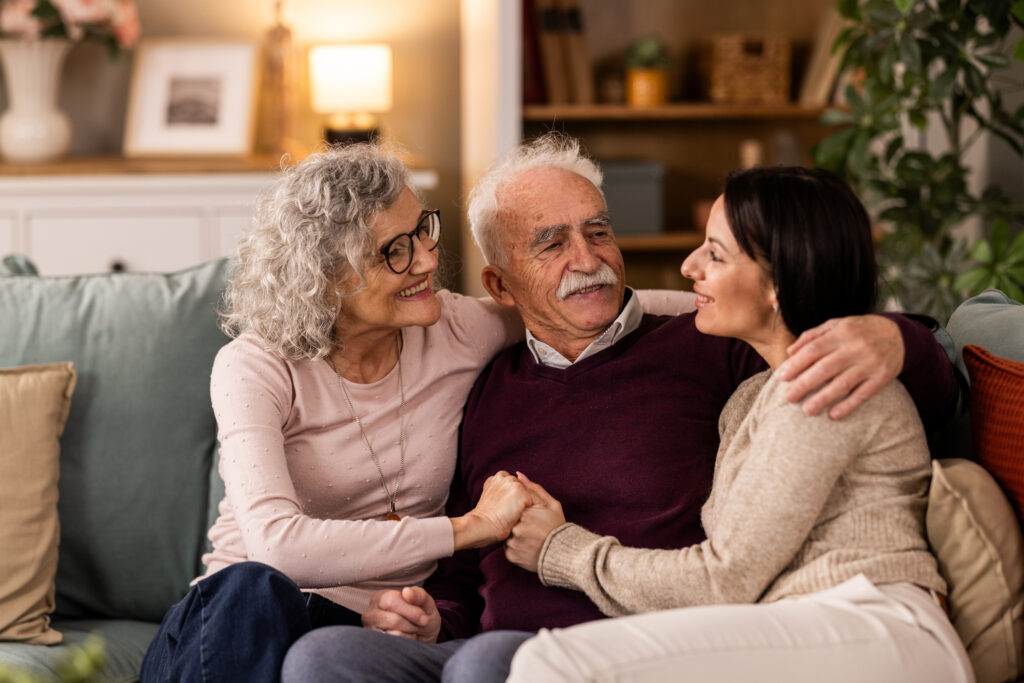 Young adult female with sitting on couch with elderly parents